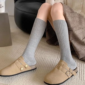 Chic khaki suede clogs with gray ribbed knit crew socks for a cozy autumn look