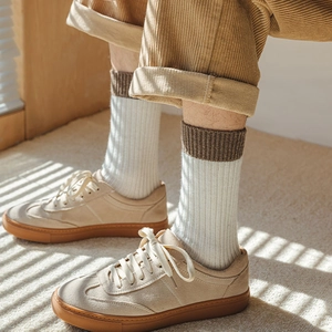 Detail view of ribbed cotton socks with contrasting cuffs worn with retro casual sneakers