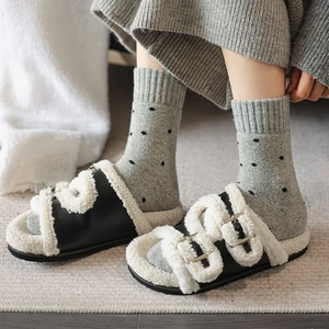 Women's black faux leather house slippers with plush sheepskin crossover straps and metal buckles