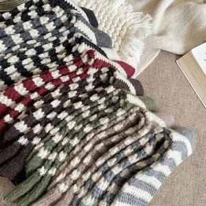 Detail view of retro wool blend socks with classic plaid and striped patterns