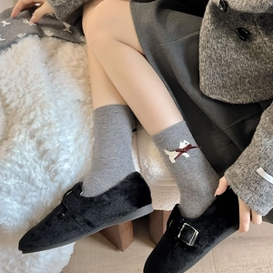 Detail of grey knitted mid-calf socks with cute puppy and red bow embroidery