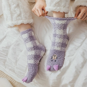 Detailed close-up of fuzzy coral fleece socks with cute 3D ears and alpaca embroidery