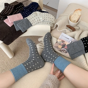 Gros plan de chaussettes en laine avec revers bleus et motifs à pois gris élégants