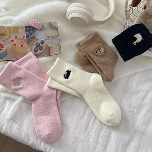 Détail de quatre paires de chaussettes d'hiver épaisses en peluche avec broderie animale mignonne