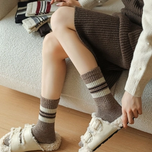 Detail of wool knit socks showing warm striped texture and cozy mid-calf winter style
