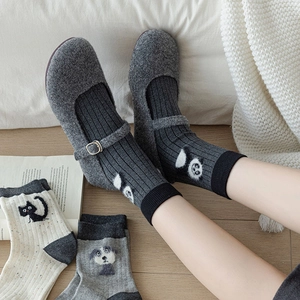 Close-up of cute cartoon panda and cat flocked socks with grey wool felt indoor shoes