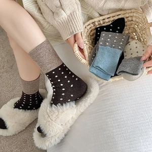 Détail de chaussettes chaudes en laine à pois avec texture tricotée et revers contrastés