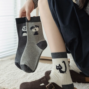 Detailed view of three pairs of ribbed knit crew socks with cute animal jacquard motifs