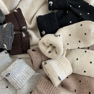 Detail of wool socks with polka dots featuring ribbed and lace cuffs in various colors