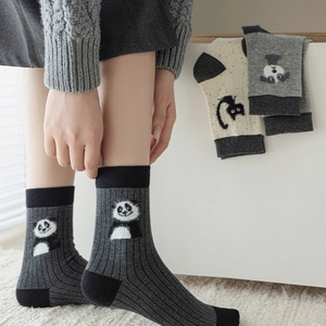 Close-up of rib-knit dark grey crew socks featuring a cute embroidered panda character