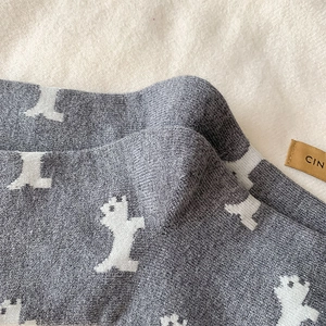 Detail of grey knitted socks featuring white bear patterns and soft ribbed texture