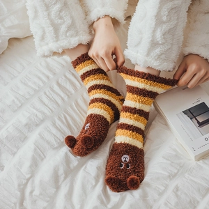 Detail of coral fleece striped socks featuring 3D bear ears and soft plush texture