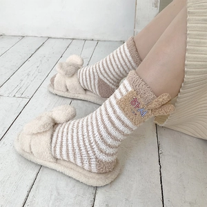 Detail of coral fleece striped socks with embroidery and plush open-toe slippers