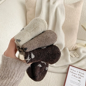 Close-up of thick wool terry socks in earth tones with warm ribbed texture and soft finish