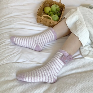 Close-up of purple and white striped coral fleece socks with cute ear detail and soft texture