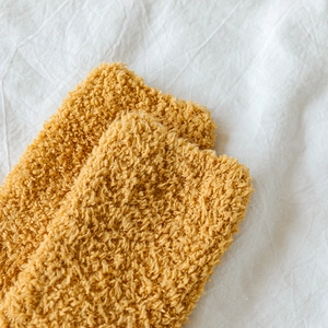 Close-up of ginger coral fleece fabric showing soft texture and warm striped plush material