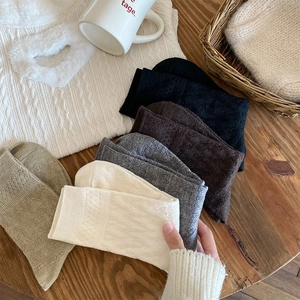 Detail of wool blend mid-calf socks featuring a 3D knit heart relief and soft texture