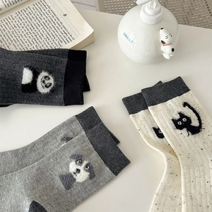 Detail of cute animal flocking patches on soft gray knit mid-calf socks for winter
