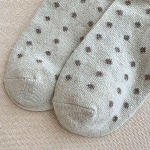 Vue macro de chaussettes en laine chaudes avec motif à pois vintage et maille côtelée