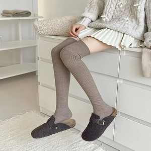 Detail von kaffeebraunen Overknee-Socken mit Rippstrick-Textur aus warmem Wollstoff