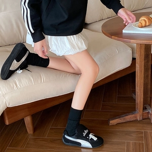 Detail view of stylish black sneakers with silver stripe paired with warm heart socks