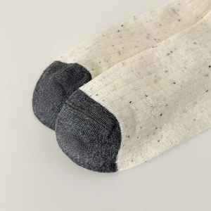 Detailed macro view of marled knit fabric texture and dark gray contrast toe on casual socks