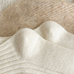 Close-up of soft knit fabric texture in cream and beige colors for warm winter socks
