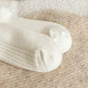 Detailed close-up of white ribbed knit socks showing thick texture and toe craftsmanship