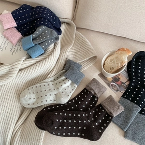 Détail de chaussettes en laine chaudes avec motifs à pois et revers côtelés variés