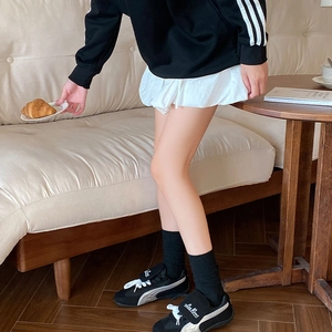 Detail of classic black and white sneakers featuring unique fold-over tongue with branding