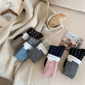 Gros plan de chaussettes en laine à pois vintage aux couleurs variées et maille douce