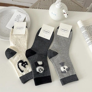 Detailed view of three pairs of cute cat-themed crew socks in neutral grey and beige colors