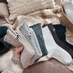 Detail showing wool blend socks with ruffled edges and cute bow embroidery details