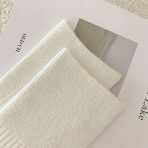 Nahaufnahme der cremeweißen Rippstrick-Overknee-Socken mit weicher Kaschmir-Textur
