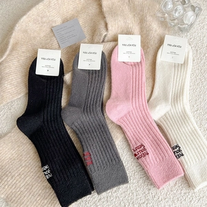 Close-up of four-color knit socks with Follow Your Heart embroidery and cotton texture
