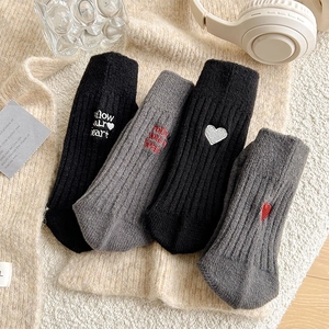 Detail showing high-elastic ribbed texture and heart embroidery on black and gray socks