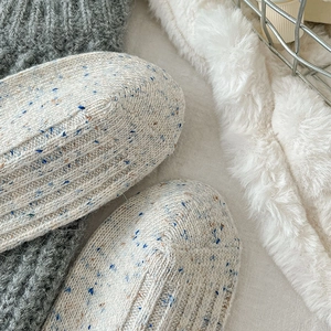 Detailopname van dikke gebreide wollen sokken met gespikkelde textuur en ribbels