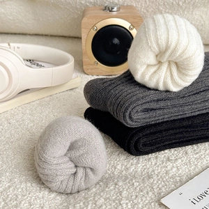 Close-up of thick ribbed knit socks in neutral colors on soft cozy fleece surface