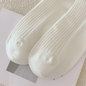 Detail der weißen Rippstrick-Overknees mit niedlichem Tierohr-Design am Saum