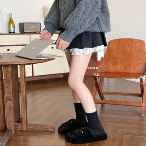 Close-up of black cashmere calf socks with knitted sweater for cozy home style