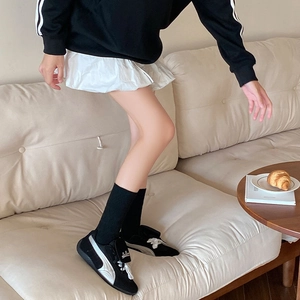 Retro black leather sneakers with silver stripes paired with heart embossed crew socks