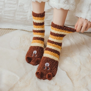 Detail of warm striped coral fleece socks with cute cartoon bear ears and soft plush texture