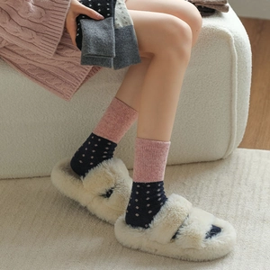 Gros plan de chaussettes en laine à pois rose et bleu avec texture côtelée pour l'hiver