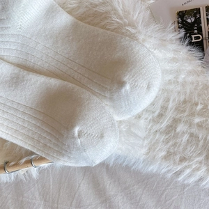 Detail shot of white ribbed knit cotton socks with seamless toe and soft texture