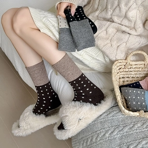 Chaussettes en laine à pois et chaussons moelleux en fausse fourrure dans un cadre chaleureux