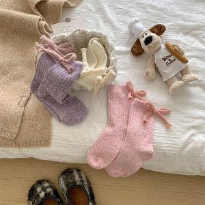 Detailed knit texture of girls wool socks featuring cute ribbons in sweet pastel colors