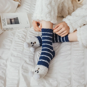 Detail of coral fleece striped socks featuring cartoon bear face and plush pom-pom ears