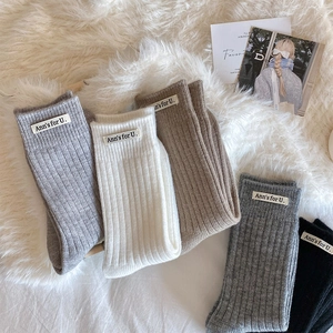 Detailed knit texture of warm winter crew socks in multiple neutral colors with cloth label