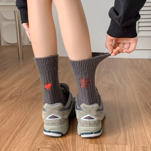Detail of dark grey ribbed socks featuring red heart and follow your heart embroidery