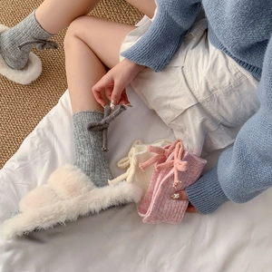 Close-up of sweet style knitted wool socks with ribbon bows in grey pink and beige